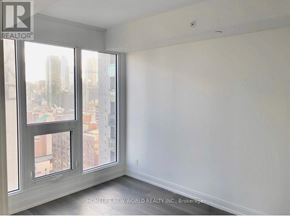 Toronto (Moss Park) condo for rent - A room with a large window overlooking a cityscape.