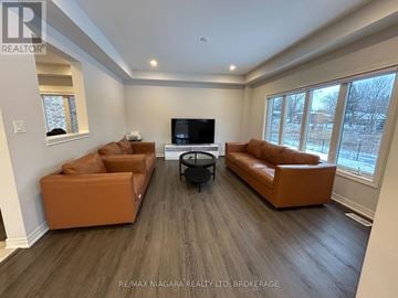 Fort Erie (Ridgeway) apartment for rent - A living room with brown leather couches and a flat screen TV.