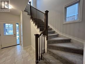 Fort Erie (Ridgeway) apartment for rent - A staircase with a black railing and a window above it.