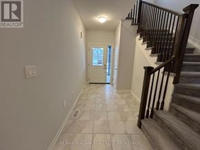 Fort Erie (Ridgeway) apartment for rent - A hallway with a staircase and a door at the end.