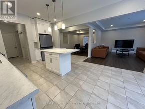 Fort Erie (Ridgeway) apartment for rent - A spacious living room with a kitchen area in the background.