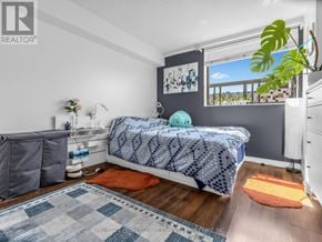 Toronto (Kensington-Chinatown) condo for rent - A bedroom with a bed, a window, and a plant.