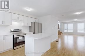 Oshawa (Eastdale) townhouse for rent - A spacious kitchen with white cabinets and a central island.