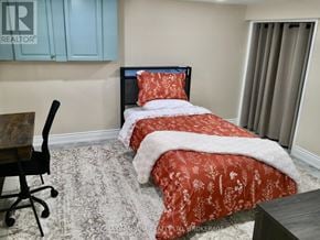 Niagara Falls (Stamford) apartment for rent - A bedroom with two beds and a chair.