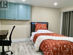 Niagara Falls (Stamford) apartment for rent - A bedroom with a bed, chair, and cabinet.