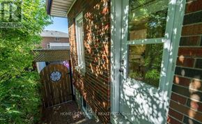 Oshawa (Mclaughlin) apartment for rent - A door with a round wooden sign on it is in front of a brick wall.