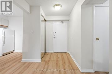 Toronto (Long Branch) condo for rent - A white hallway with wood floors and a white door.
