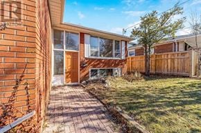 Toronto (Kingsview Village-The Westway) apartment for rent - A house with a brown fence and a tree in front.