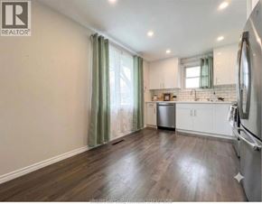 Lakeshore apartment for rent - A kitchen with wooden floors and white cabinets.