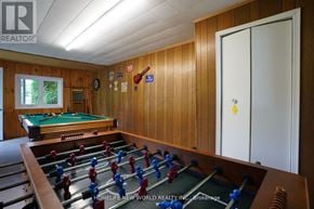 Kawartha Lakes (Fenelon) apartment for rent - A foosball table is in the middle of a room with wooden walls and a pool table.