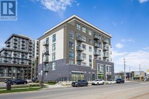 Hamilton (Waterdown) condo for rent - A modern multi-story building with a parking lot in front.
