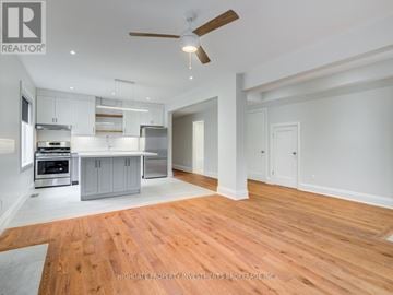 Toronto (Casa Loma) apartment for rent - A spacious kitchen with white cabinets and a wooden floor.