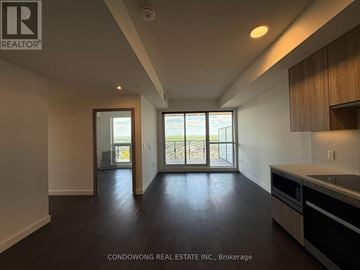 Toronto (Bayview Village) condo for rent - A spacious room with a kitchen area and a view of the outside through the windows.