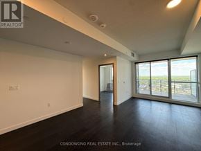 Toronto (Bayview Village) condo for rent - A spacious room with a view of the city through large windows.
