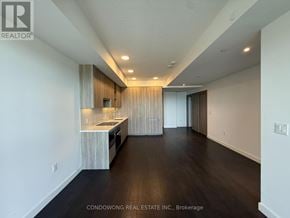 Toronto (Bayview Village) condo for rent - A spacious, well-lit kitchen with dark wood floors and white walls.