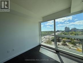 Toronto (Bayview Village) condo for rent - A room with a large window overlooking a cityscape.