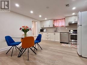 Toronto (Yorkdale-Glen Park) apartment for rent - A kitchen with a table and chairs and a vase of flowers.