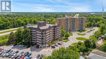 Guelph (Kortright West) condo for rent - A large apartment complex with a parking lot in front.