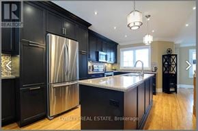 Whitby (Pringle Creek) townhouse for rent - A modern kitchen with black cabinets and a stainless steel refrigerator.
