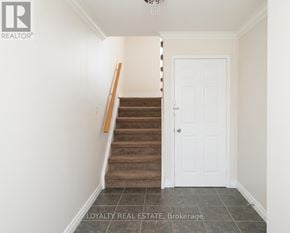 Whitby (Pringle Creek) townhouse for rent - A hallway with a staircase and a white door.