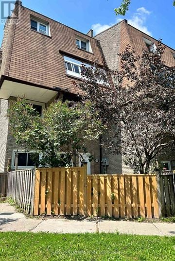 Toronto (Scarborough Village) townhouse for rent - A brown building with a wooden fence in front of it.