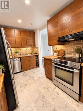 Toronto (Scarborough Village) townhouse for rent - A modern kitchen with wooden cabinets and stainless steel appliances.