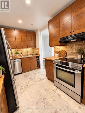 Toronto (Scarborough Village) townhouse for rent - A modern kitchen with wooden cabinets and stainless steel appliances.