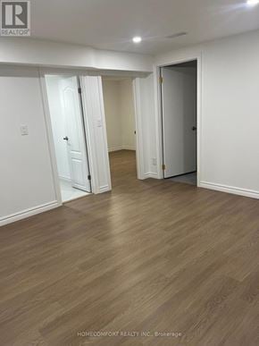 Richmond Hill (Devonsleigh) apartment for rent - A room with wooden flooring and white walls, with two doors open.