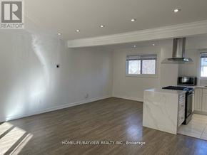 Newmarket (Central Newmarket) apartment for rent - A spacious, empty room with a kitchenette area and a window.