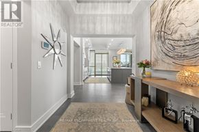 Burlington (Brant) condo for rent - A hallway with a large sunburst mirror on the wall.