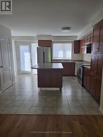Mississauga (Churchill Meadows) house for rent - A kitchen with brown cabinets and a white fridge.