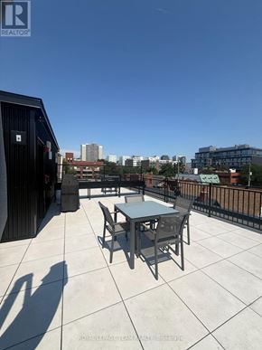 Ottawa apartment for rent - A balcony with a table and chairs overlooking a cityscape.