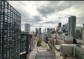 Toronto (Church-Yonge Corridor) condo for rent - A cityscape with tall buildings and a cloudy sky.