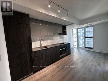 Toronto (Church-Yonge Corridor) condo for rent - A modern kitchen with dark wood cabinets and a white countertop.