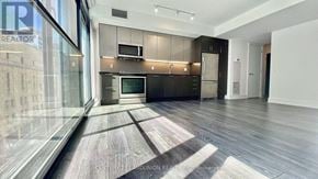 Toronto (Church-Yonge Corridor) condo for rent - A modern kitchen with dark wood floors and a large island.