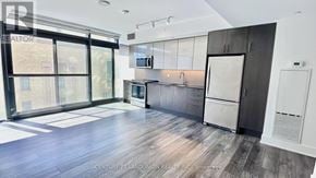 Toronto (Church-Yonge Corridor) condo for rent - A spacious kitchen with dark wood floors and modern appliances.