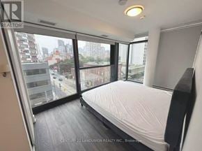 Toronto (Church-Yonge Corridor) condo for rent - A bedroom with a large bed and a view of the city.