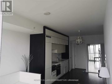 Toronto (Bay Street Corridor) condo for rent - A well-lit, spacious kitchen with white cabinets and a black countertop.