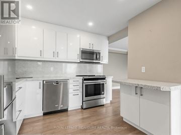 Markham (Royal Orchard) condo for rent - A modern kitchen with white cabinets and stainless steel appliances.