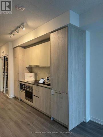 Vaughan (Vaughan Corporate Centre) condo for rent - A modern kitchen with wooden cabinets and a stainless steel oven.