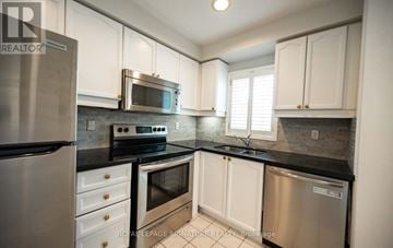 Mississauga (Clarkson) townhouse for rent - A kitchen with white cabinets and stainless steel appliances.