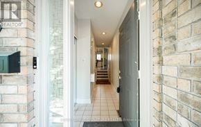 Mississauga (Clarkson) townhouse for rent - A hallway with a brick wall and a door on the right.