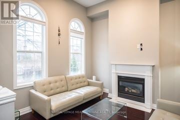 Mississauga (Churchill Meadows) townhouse for rent - A living room with a white couch and a fireplace.