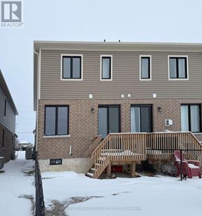 Zorra (Thamesford) townhouse for rent - A brown house with a wooden deck in front.