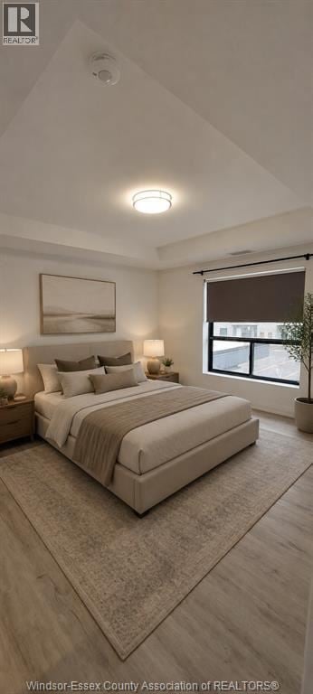 Windsor condo for rent - A well-lit bedroom with a large bed and a window.