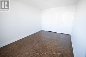 Toronto (Playter Estates-Danforth) condo for rent - A room with wooden flooring and white walls, with two doors.