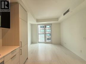 Toronto (Church-Yonge Corridor) condo for rent - A spacious, empty room with a large window and a wooden floor.