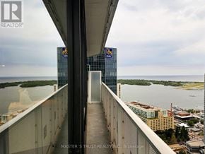 Toronto (Waterfront Communities) condo for rent - A view from a high-rise building looking out over a body of water with a bridge in the distance.