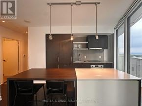 Toronto (Waterfront Communities) condo for rent - A modern kitchen with a dining table and chairs.