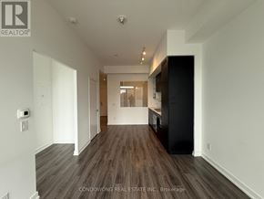 Toronto (Bay Street Corridor) condo for rent - A spacious hallway with wooden floors and white walls.